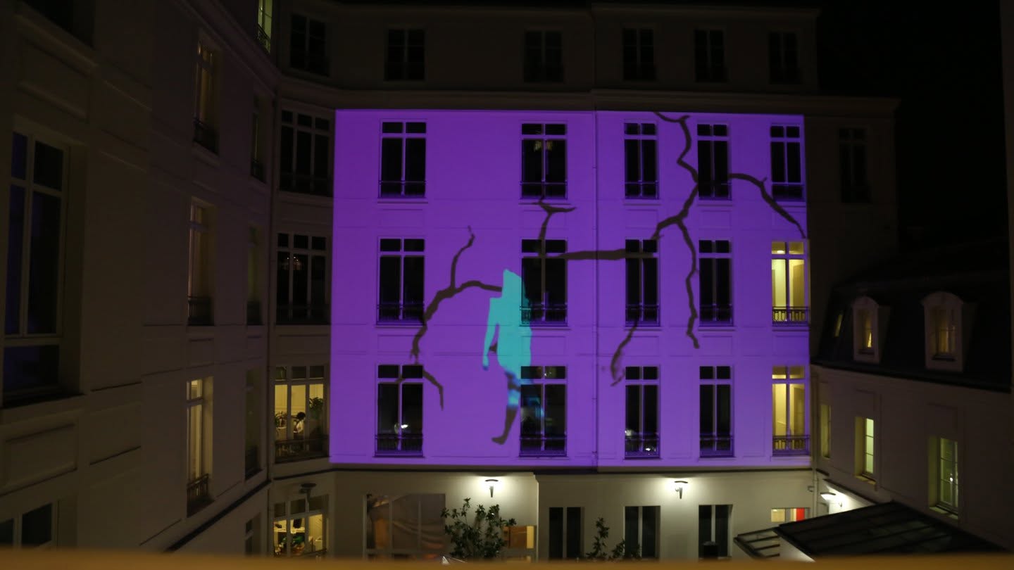 Projection mapping violette avec fissures et silhouette sur la façade de l’Organisation internationale de la Francophonie à Paris