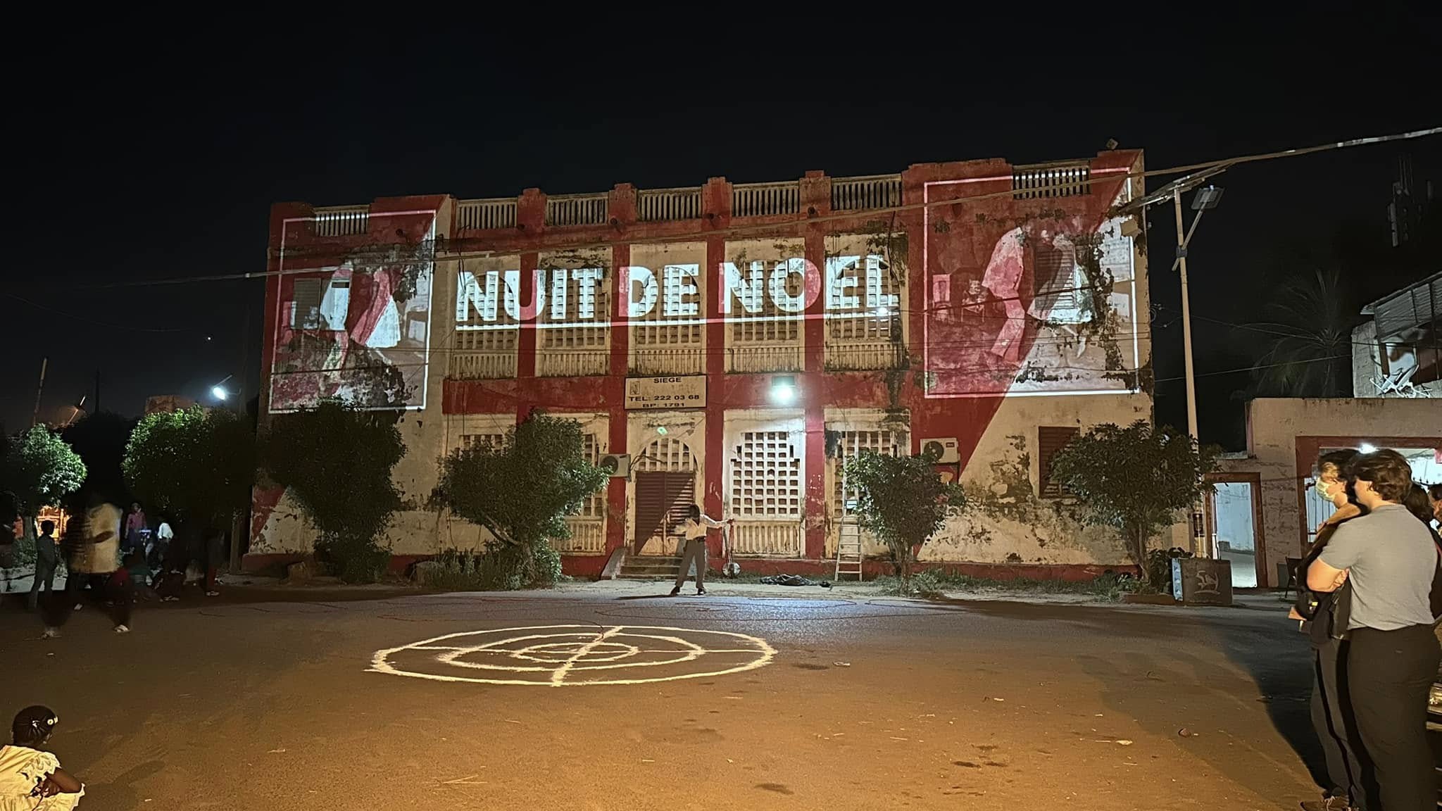 Vue d’ensemble nocturne du mapping projeté sur la façade devant le public