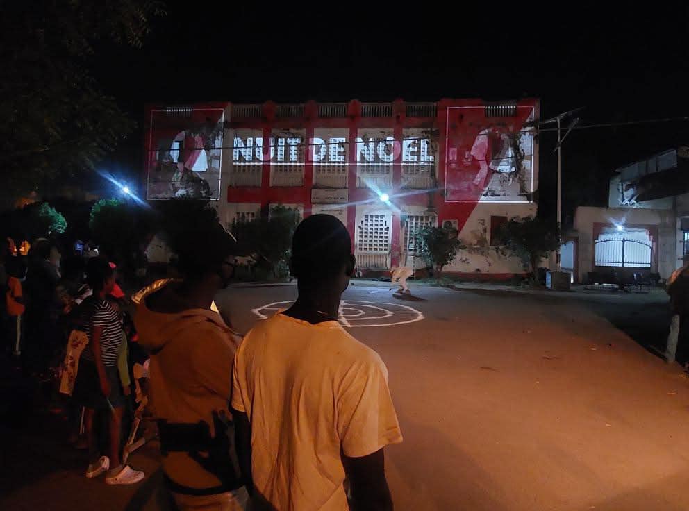 Public observant la projection mapping sur la façade pendant les Rencontres de Bamako
