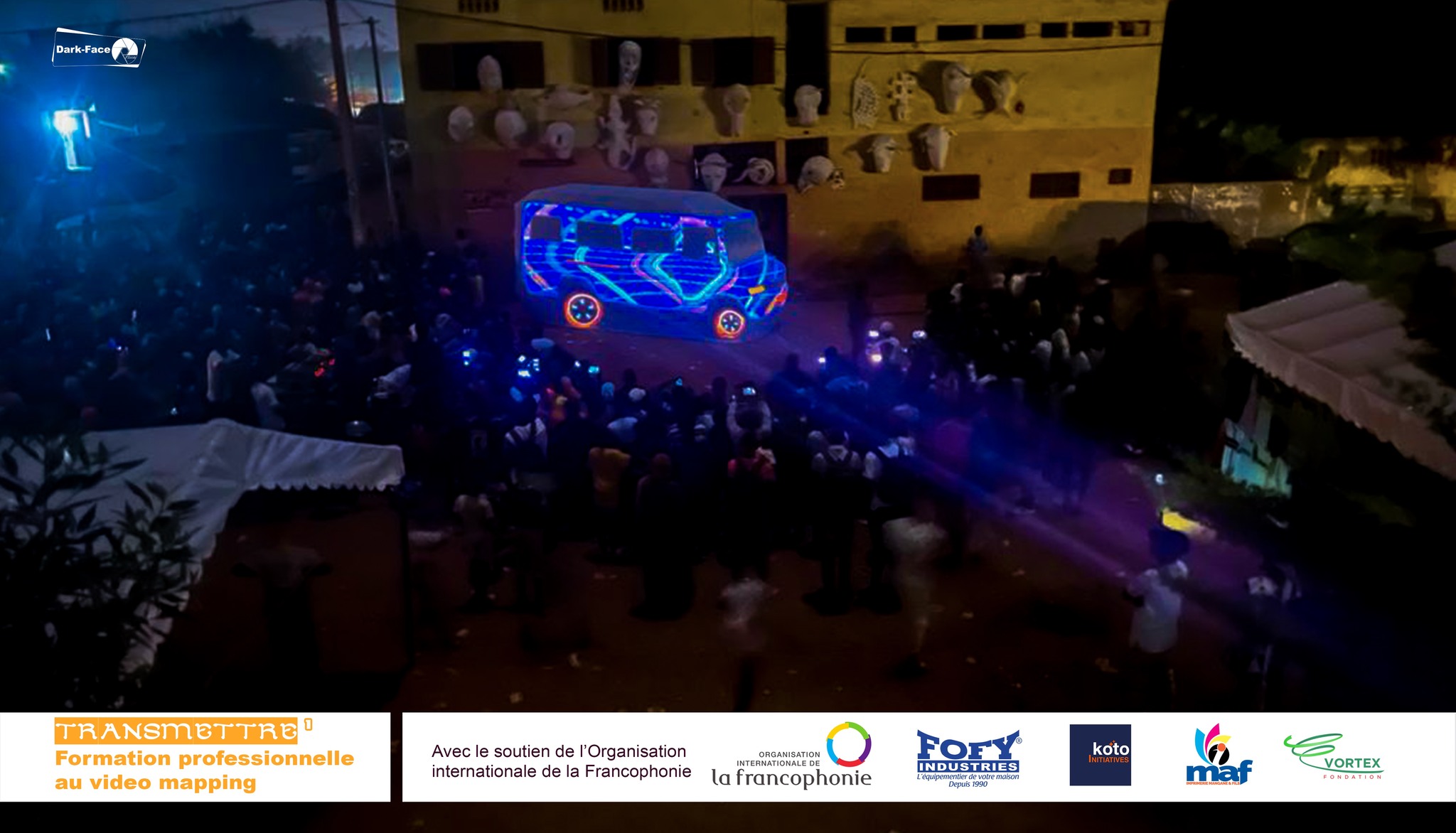 Restitution publique de TRANSMETTRE avec une projection vidéo sur un Sotrama devant le public